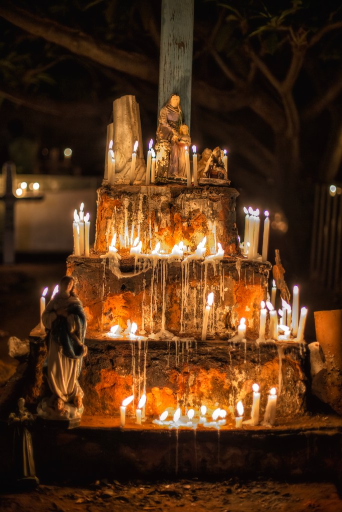 Velário circular de quatro andares repleto de velas acesas. No topo está uma imagem de Santa Ana com Maria menina, e na base, uma imagem de Nossa Senhora da Conceição.